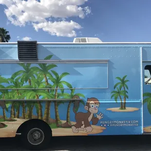a blue food truck parked in a parking lot