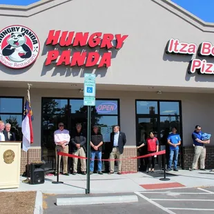 a large group of people standing in front of a restaurant