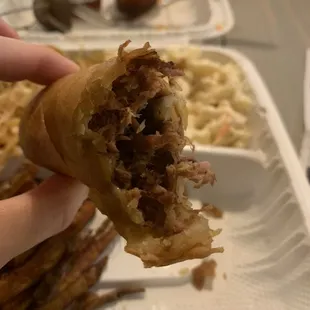 a hand holding a half eaten sandwich