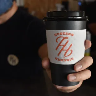 a hand holding a coffee cup