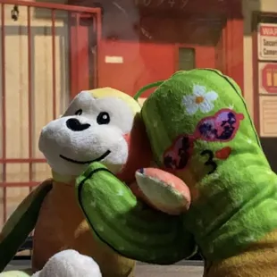 two stuffed animals in front of a sign