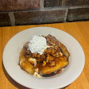 a plate of bananas with whipped cream and walnuts