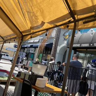 people sitting at tables under a canopy
