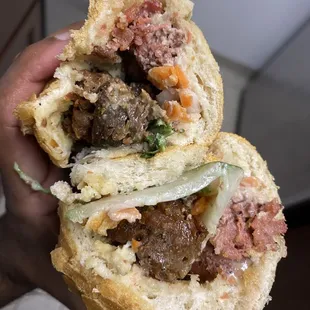 a hand holding a sandwich