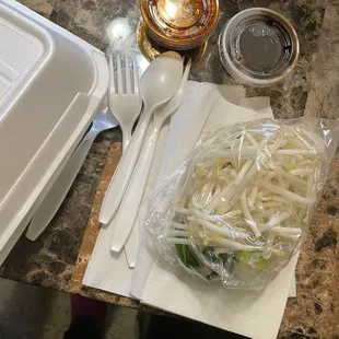 a plastic container with a plastic fork and a plastic spoon and a plastic container with a plastic fork and a plastic
