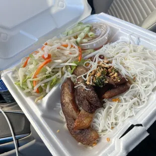 a hand holding a styrofoam container