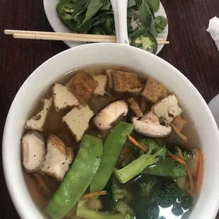 Rice noodle soup with fresh side vegetable