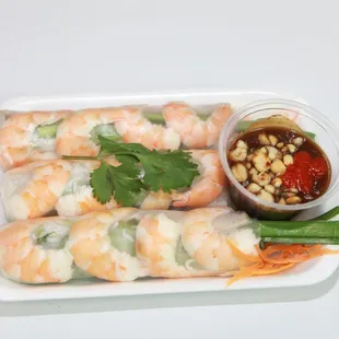 a plate of shrimp rolls with dipping sauce