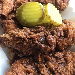 a pile of fried chicken with a pickle