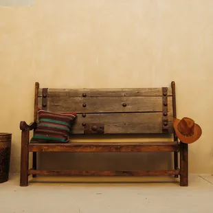 a wooden bench with a hat on it