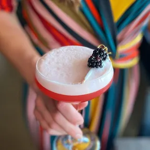 a woman holding a cocktail