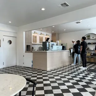 two people standing in a coffee shop