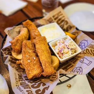 a basket of fried fish with coleslaw, coleslaw