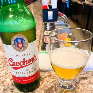 a glass of beer next to a bottle of beer