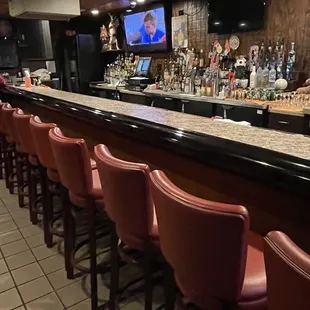 a bar with red leather chairs