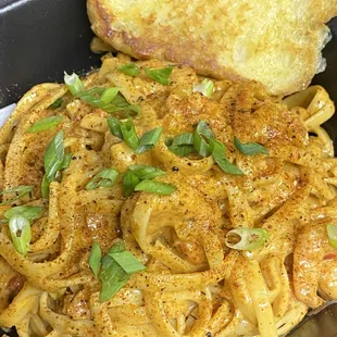 a plate of pasta and a piece of bread