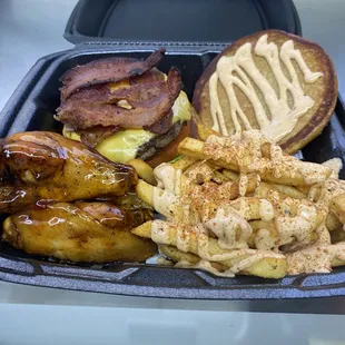 a tray of food including a burger, french fries, and other foods