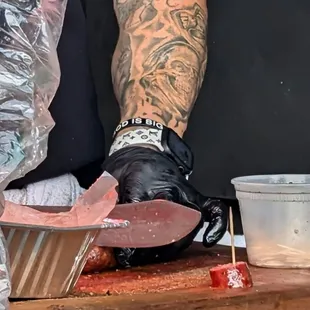 Person cutting sausage tasters for people in line