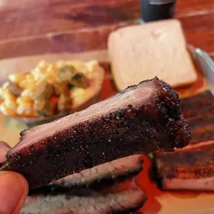 a hand holding a piece of meat