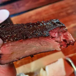 a hand holding a piece of meat