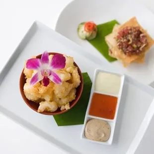 a small bowl of sushi and a small bowl of dipping sauce