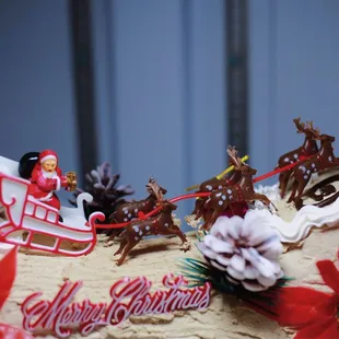 a christmas cake decorated with a sleigh and reindeers