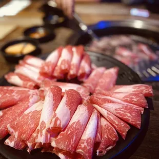 a plate of sliced meat on a table