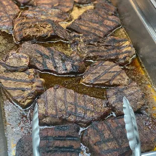 steaks being cooked in a pan
