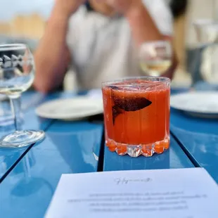 a woman sitting at a table with a drink