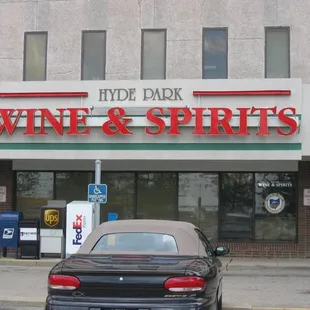 a car parked in front of a wine and spirits store