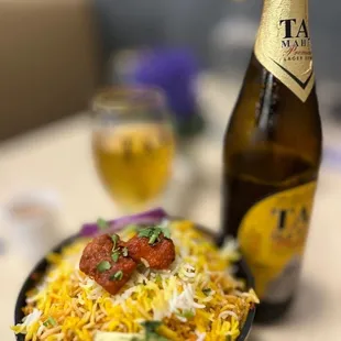 a bowl of birya rice and a bottle of beer