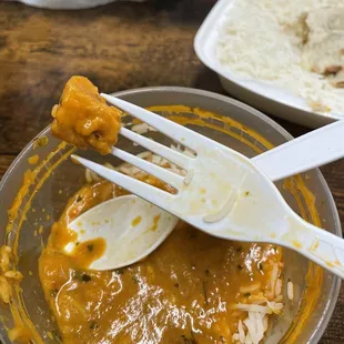 a bowl of curry with a fork in it