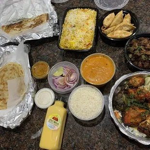 Butter Garlic Naan, assorted tandoor bone-in, fried momo, Butter Chicken, Dum Biryani Chicken, chicken nalakaram, parotta, Mango lassi.