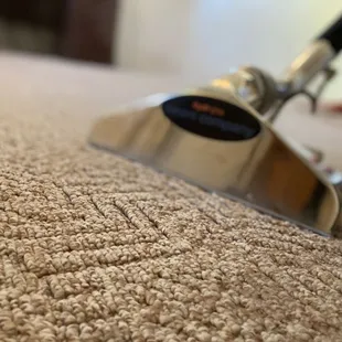 a person using a vacuum to clean a carpet