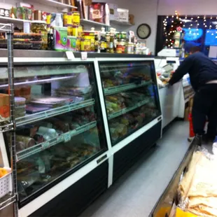 a man standing in front of a refrigerated display case