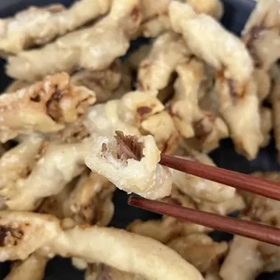 a close up of a plate of food with chopsticks