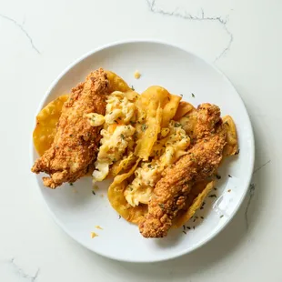 a plate of fried chicken with macaroni and cheese