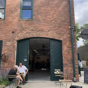 a man sitting on a bench in front of a building