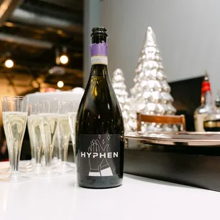New ad agency name HYPHEN on champagne bottle