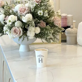 a vase of flowers and a cup of coffee