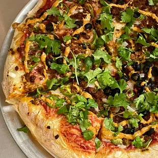 El Matador Pizza has Red Sauce, Soyrizo, White Onions, Jalapeños, Black Olives, Fresh Cilantro with a Hypnotic Smokey Chipotle Spiral