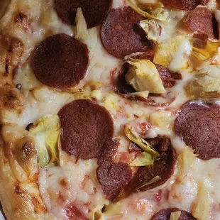 Vegan pizza with pepperoni, artichokes, and pineapple