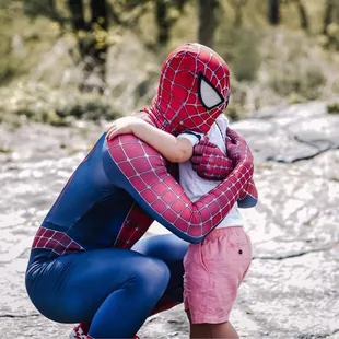 Spider man hugging the bday boy.