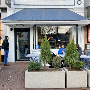 people sitting outside of a restaurant