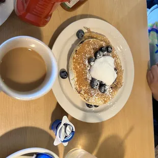 a plate of pancakes and a cup of coffee