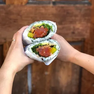 a person holding a sushi