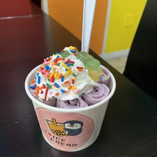 taro ice cream with whipped cream, sprinkles, and gummy bears on top