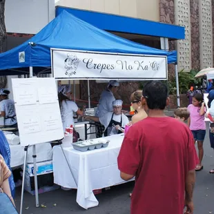 a crowd of people at a food stand