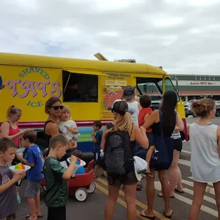 a group of people standing in front of a food truck