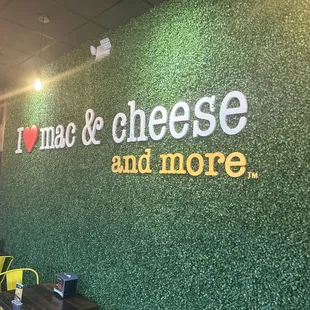 a green wall with the words mac and cheese and more